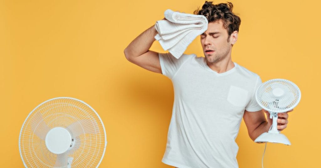 ragazzo che usa il ventilatore per vincere il caldo