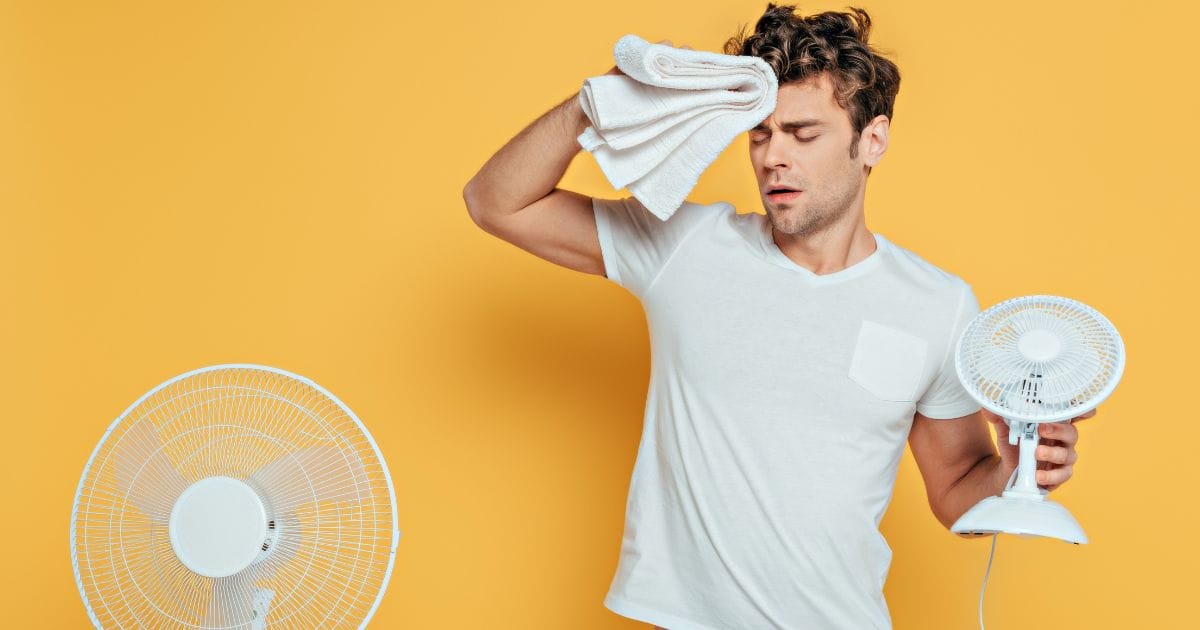 ragazzo che usa il ventilatore per vincere il caldo
