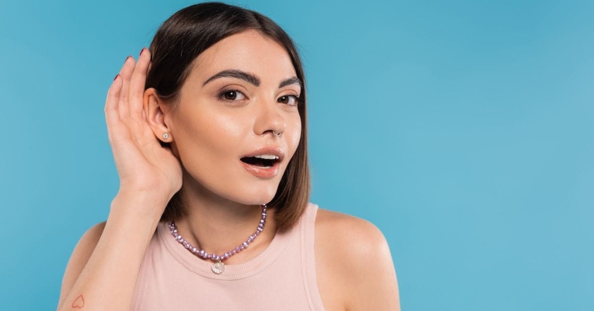 ragazza con mano sull'orecchio nell'atto di ascoltare