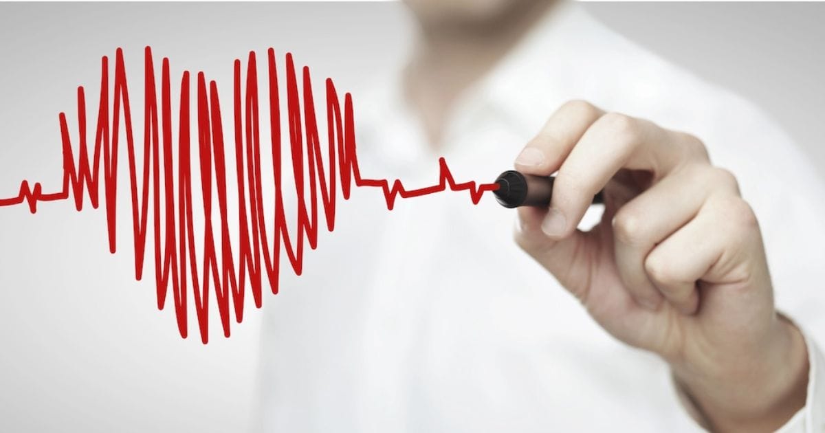 uomo che traccia segno del cuore con un pennarello perché tra i benefici del magnesio e del potassio c'è il supporto al cuore