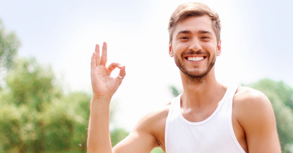 ragazzo felice fa il segno ok dopo avere assunto integratori di ferritina (o meglio integratori di ferro).