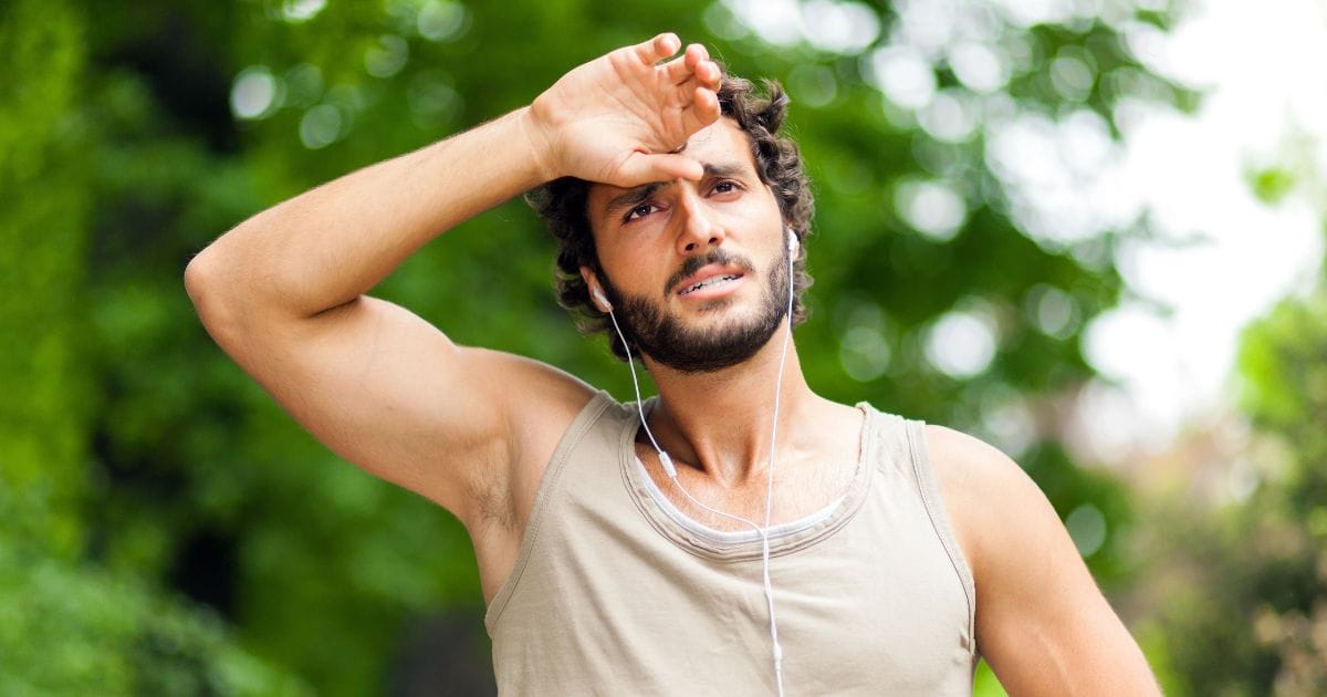 ragazzo mette la mano sulla fronte mentre corre in primavera