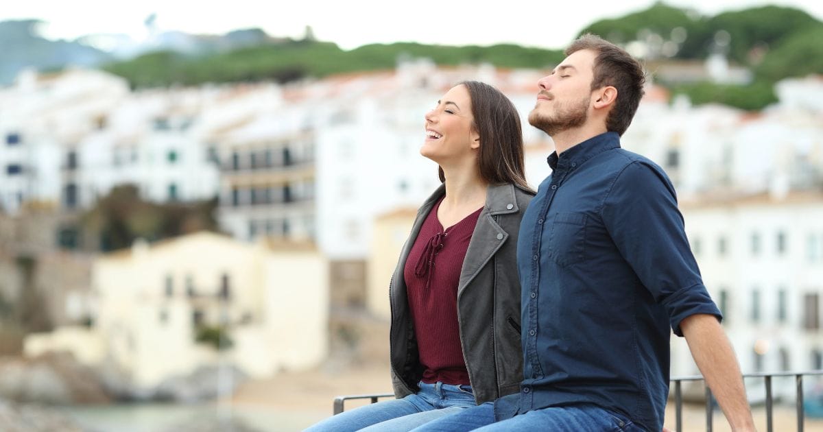 giovane coppia seduta su un muretto è piena di energia
